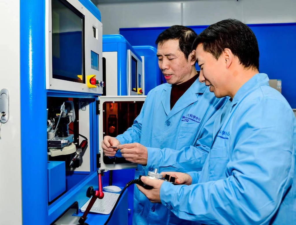 2022年4月，夏庆友（左一）在种质创制科学中心调试自研发设备。受访者供图