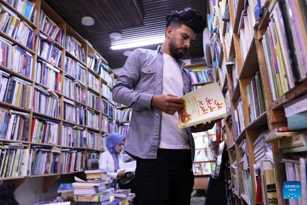 An Iraqi student reads a book on the Belt and Road Initiative, at a bookstore in Baghdad, Iraq, Nov. 21, 2022. (Xinhua/Khalil Dawood)