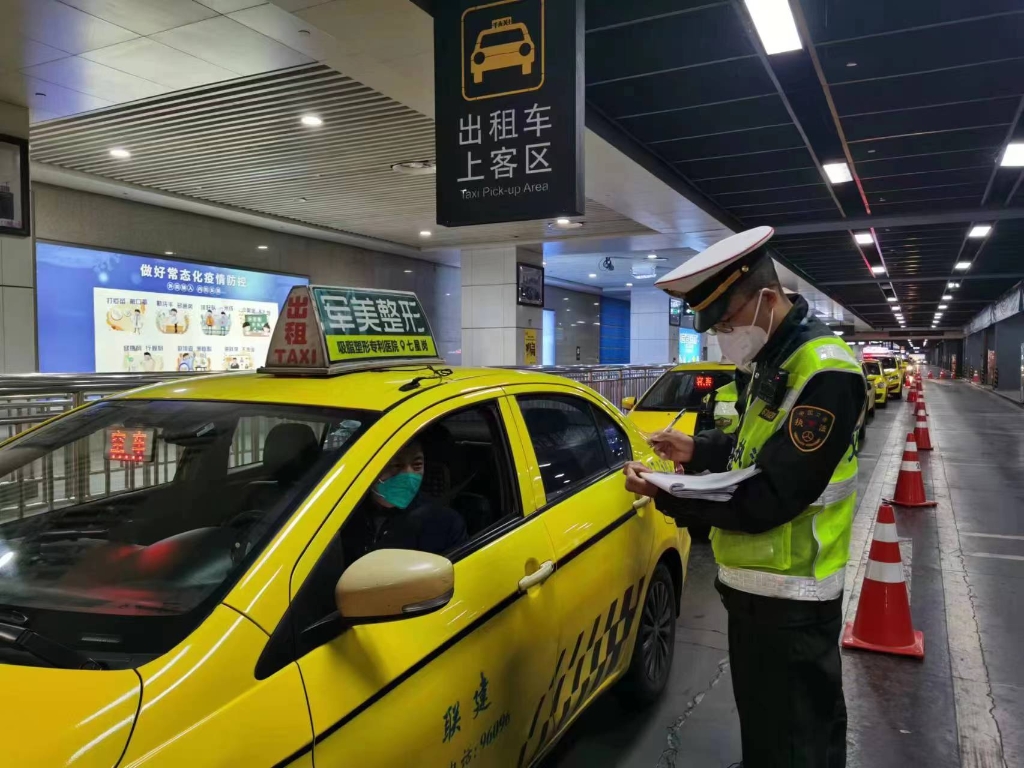 在重庆北站北广场出租车候乘站点，执法队员进行检查，并提醒出租车驾驶员做好个人防护。重庆交通执法部门供图