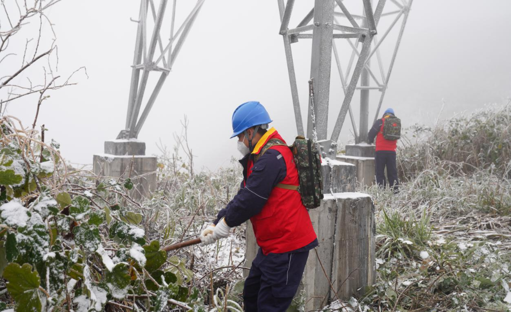 国网秀山供电公司员工清理铁塔周边杂草。国网重庆市电力公司供图