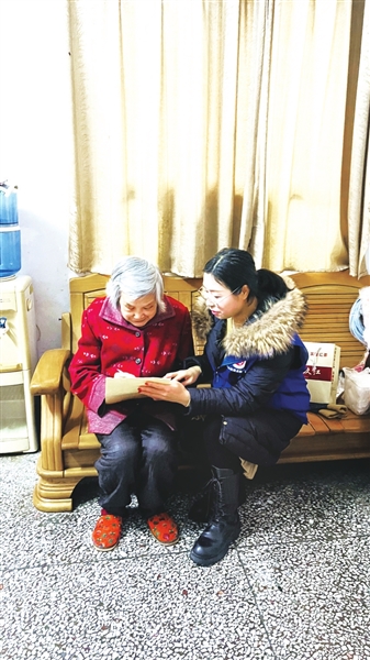 志愿者为姚仕芬（左）介绍养老服务清单。通讯员 罗超 胡宁 供图