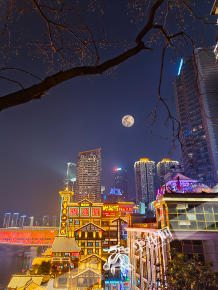 15日晚，一轮明月在重庆洪崖洞景区上空升起（二次曝光图片）。华龙网-新重庆客户端记者 石涛 摄