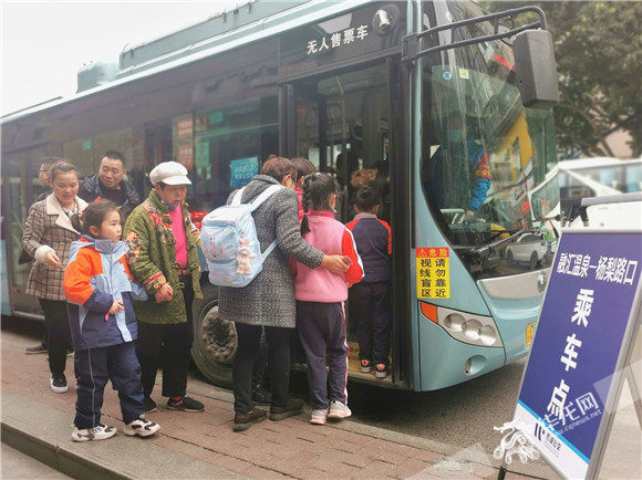学生和家长依次坐上定时公交车。华龙网-新重庆客户端记者 王庆炼 摄