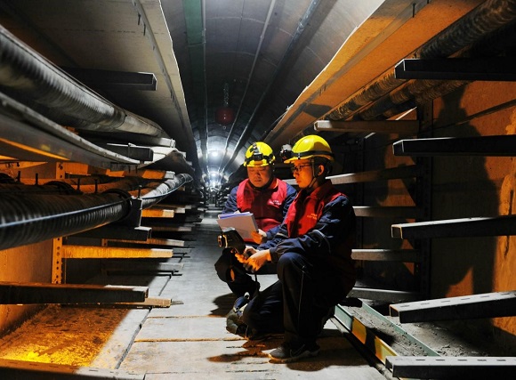 叶练（右1）跟着师傅在解放碑地下环形电力隧道开展特巡特维。通讯员 韩薇 摄