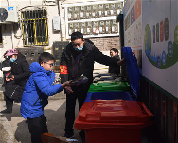 小区监督员指导小孩正确投放可回收物。特约通讯员  隆太良  摄