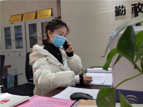 社区工作人员林香均正在电话了解居家隔离人员情况。潼南区委宣传部供图   华龙网发