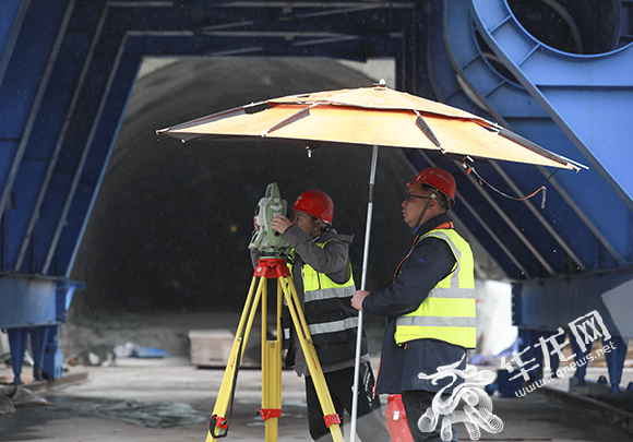 工人冒雨在隧道口进行测量。华龙网-新重庆客户端 首席记者 李文科 摄