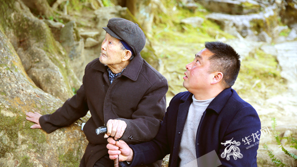 110岁的老人代明祥在千年金丝楠木树下。华龙网-重庆客户端记者张馨月 摄