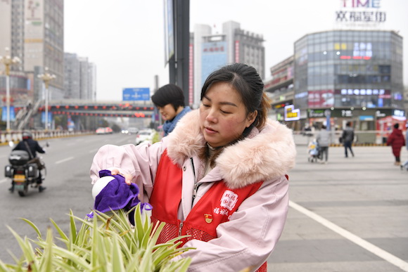 福城社区志愿者在时代广场用双手扮靓城市。江津区双福街道供图 华龙网发