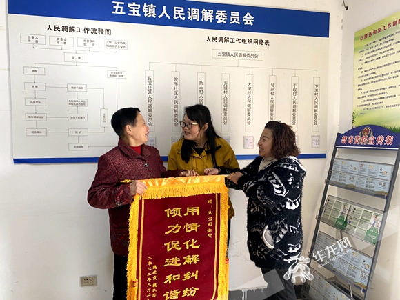 两家人携手送锦旗。华龙网-新重庆客户端记者 李黎 摄