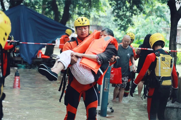 3张海洋将一名老人从洪峰中营救出来。沙坪坝区消防救援支队供图 华龙网发