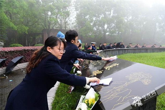 祭扫人员正在擦拭墓碑。华龙网-新重庆客户端记者 张雪莹 摄