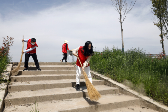 梁平区龙溪河（仁贤段），党员志愿者在清扫步道-。通讯员 向成国 摄