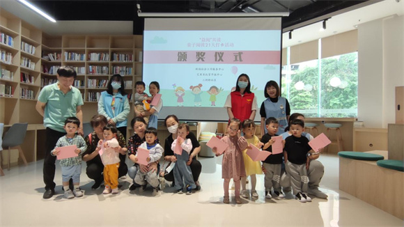工作人员为参与亲子阅读打卡活动的优秀家庭颁奖。江北城街道供图