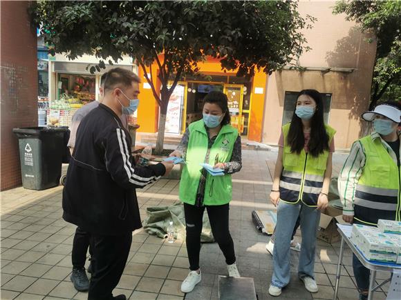 2志愿者正在向居民派发垃圾分类的宣传册。通讯员 尹欢欢 摄