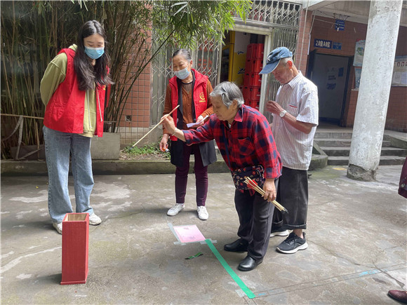 社区居民尝试传统趣味运动会项目“投壶”。南岸区回龙湾社区供图 华龙网发