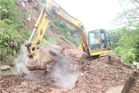 2大足区公路养护中心工人加紧处置坡堵塞路面的泥石。特约通讯员 蒋文友 摄