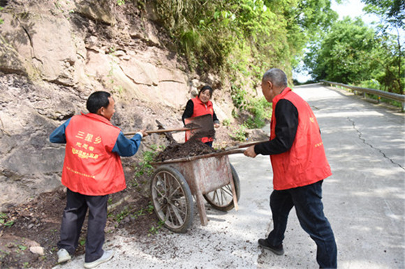 志愿者在清理沟内泥石。特约通讯员  隆太良  摄