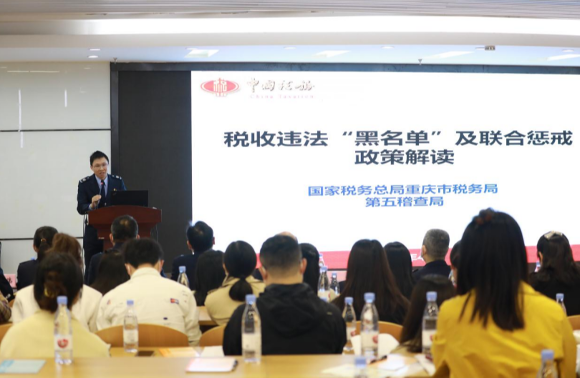 重庆市税务局第五稽查局税务人员讲解税收违法“黑名单”政策。通讯员李靖 摄