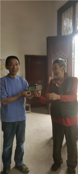 胡昌平（左）从冉崇培老人手中接过丢失的物品。陈柳蓉 摄