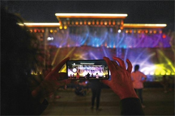 近日，市民在拍摄都梁广场音乐喷泉变化多样的造型。通讯员  向成国 摄