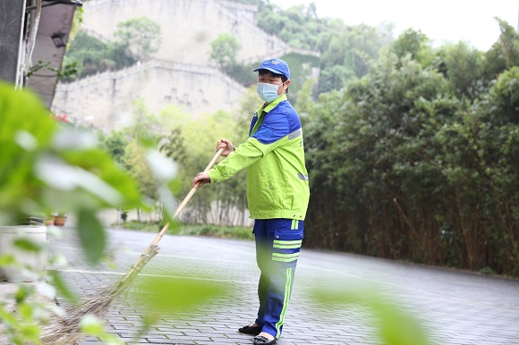 北碚区北温泉街道云清路，环卫工人胡桂莲正拿着扫帚认真打扫人行道上的环境卫生。通讯员  熊辉摄