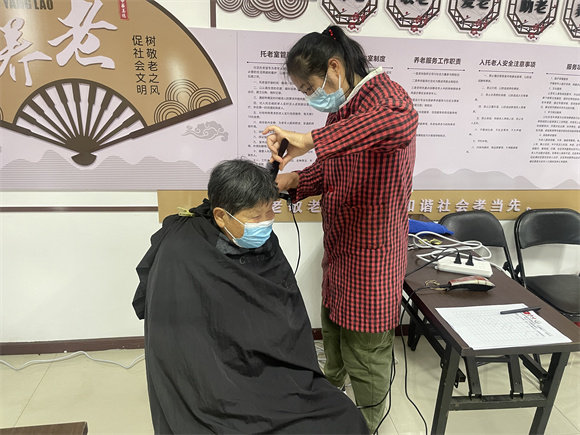 志愿者为老年人理发。南坪镇回龙湾社区供图 华龙网发