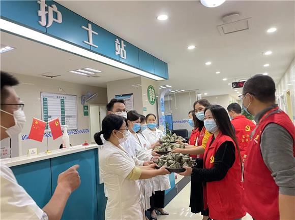 党员代表们为龙山社区卫生服务中心医护人员送上亲手包制的粽子。 通讯员 徐诗颖 摄