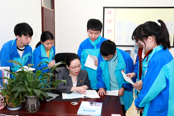 李玲（左三）为学生讲解课本。 受访者供图 华龙网发