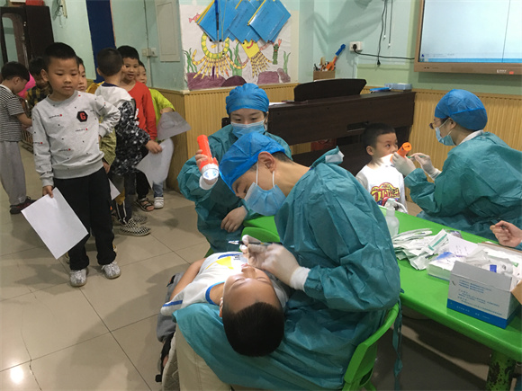 幼儿园小朋友们在积极配合牙科医生进行口腔检查和全口牙齿涂氟防龋。通讯员 胡琴 摄