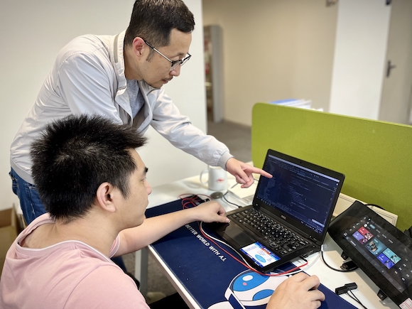 马鸿鹏（图右穿白衣者）与同事进行智能车载系统测试。