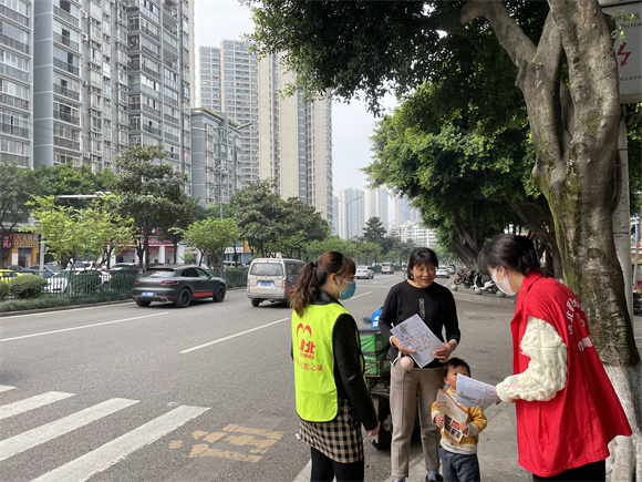 4龙山街道松牌路社区志愿者向过往行人宣传文明过马路。通讯员 左春燕 摄