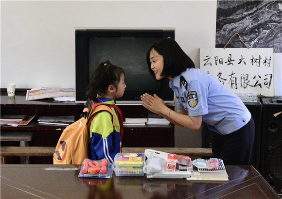 左欣和小学生在一起。云阳县公安局供图 华龙网发