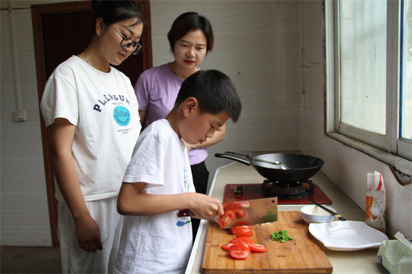 黄艳教孩子学做饭。通讯员 陈楠 摄