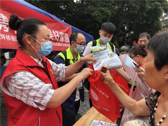 1志愿者向居民宣传垃圾分类知识。九龙坡区城市管理局供图