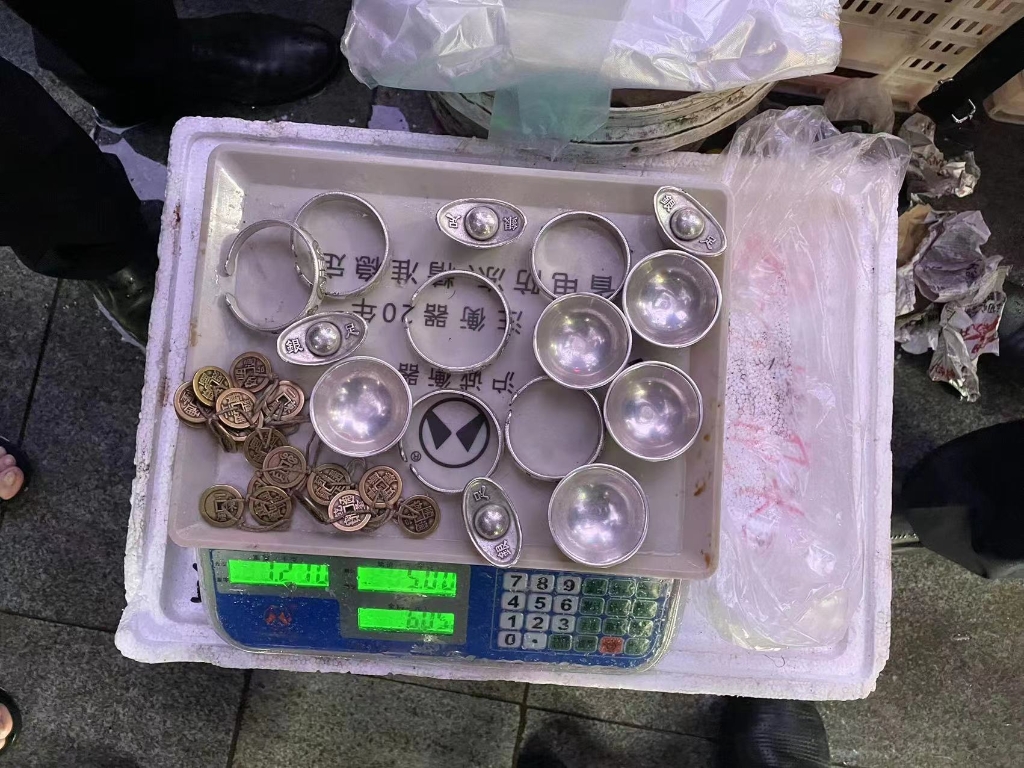 1女子兜售的所谓银元宝、古币。沙坪坝区警方供图