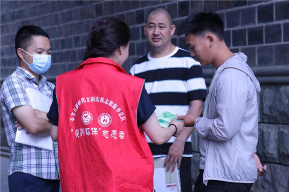 志愿者向居民发放宣传资料。奉节县生态环境局供图