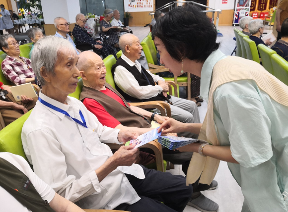 九龙坡区市场监管局向老年人发放防诈手册。受访单位供图