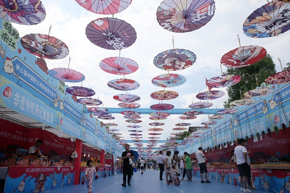 游客在黔江鸡杂美食文化节上游美食街。 通讯员 杨敏 摄