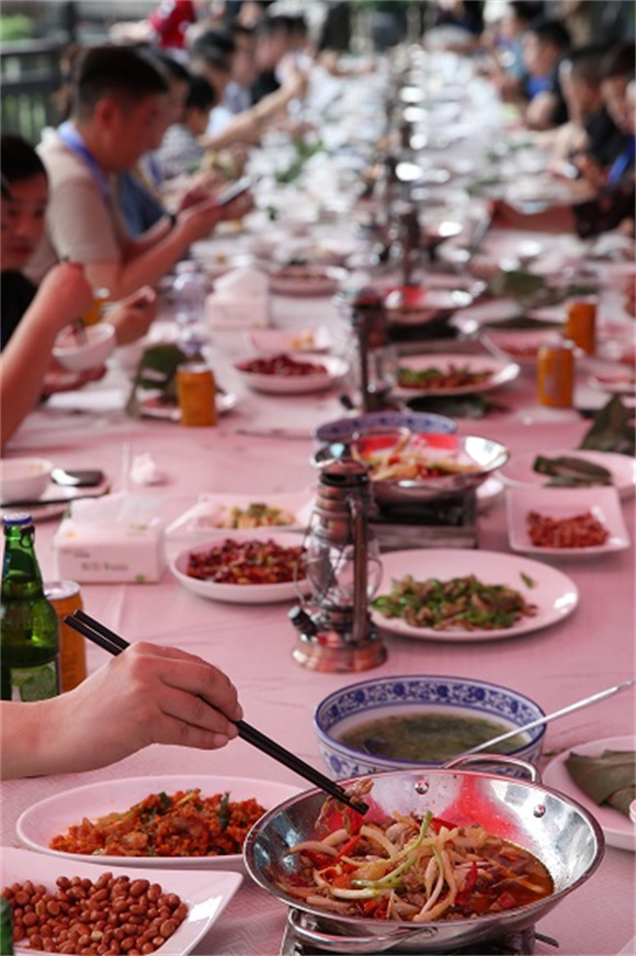 游客在黔江鸡杂美食文化节上吃黔江鸡杂长桌宴。通讯员 杨敏 摄