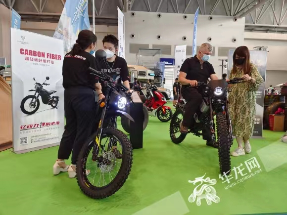 市民在摩托车展区，体验重庆本土品牌珠峰钇动力的新款电动越野摩托车。华龙网-新重庆客户端记者 石涛 摄