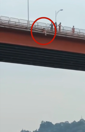 0女子坐在大桥护栏外侧，试图跳江。通讯员 吴建华 摄