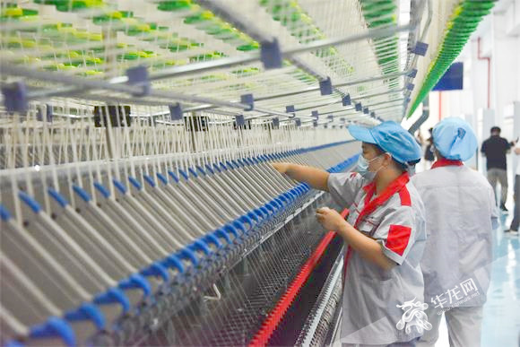 江西卫棉纺织项目里的工人正在检查机器运转情况。华龙网-新重庆客户端记者 雷其霖 摄
