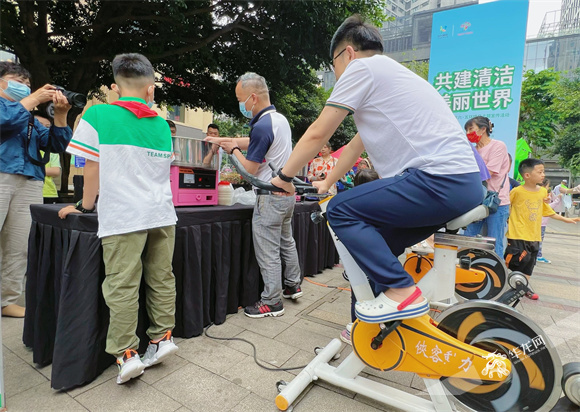 在江北区六五环境日主题宣传活动上，众多家庭体验用脚踏车发电制作棉花糖。华龙网-新重庆客户端 李永欢 摄