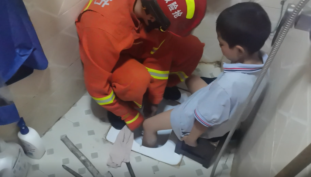 1消防员细心地用毛巾包裹男孩左脚。黔江消防供图