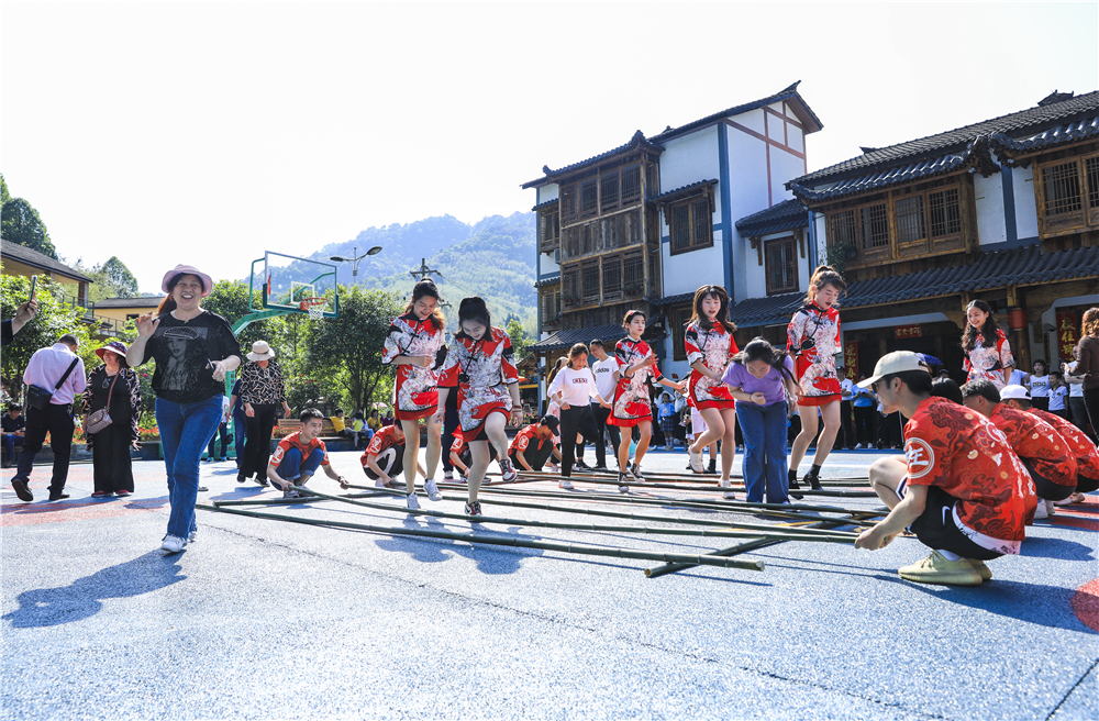 6竹杆舞团带领游客一起，在竹山镇猎神村跳竹竿舞。通讯员 熊伟  摄