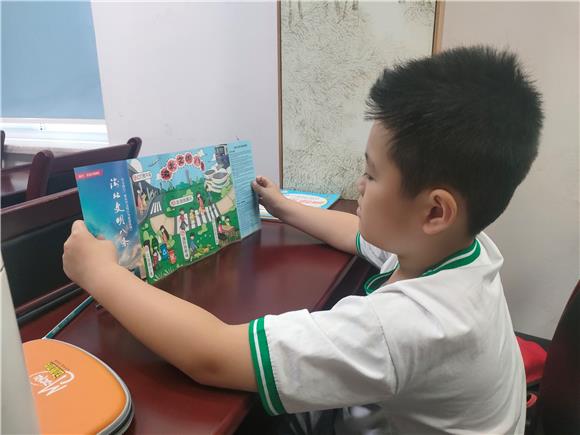 小朋友学习《重庆市文明行为促进条例》宣传手册。通讯员 王国君 摄