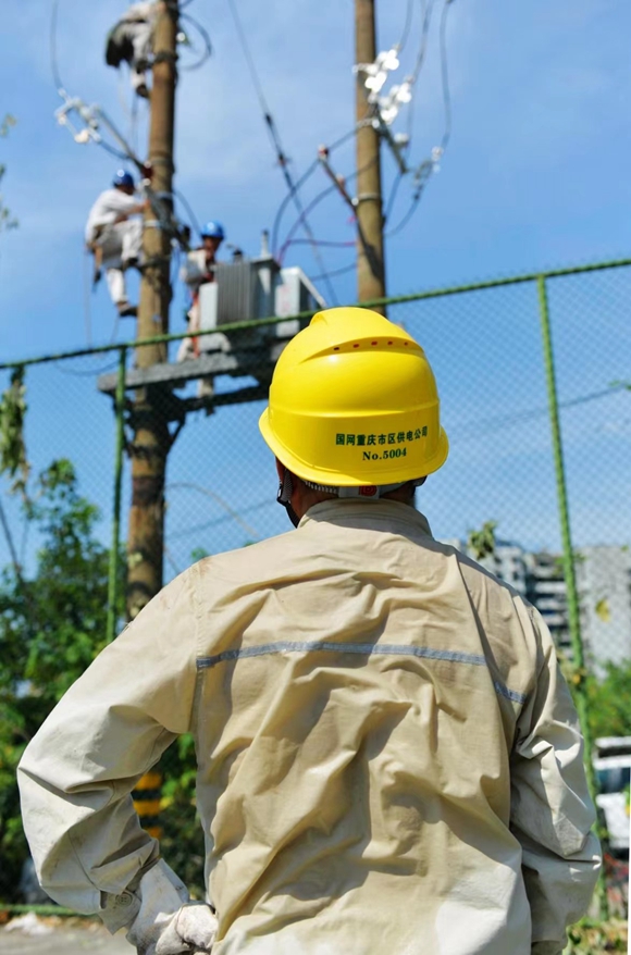 7月12日，室外气温高达41摄氏度，国网重庆市电力公司员工在渝中区枇杷山后街对柱上变压器进行更换。 国网重庆市电力公司供图  华龙网发