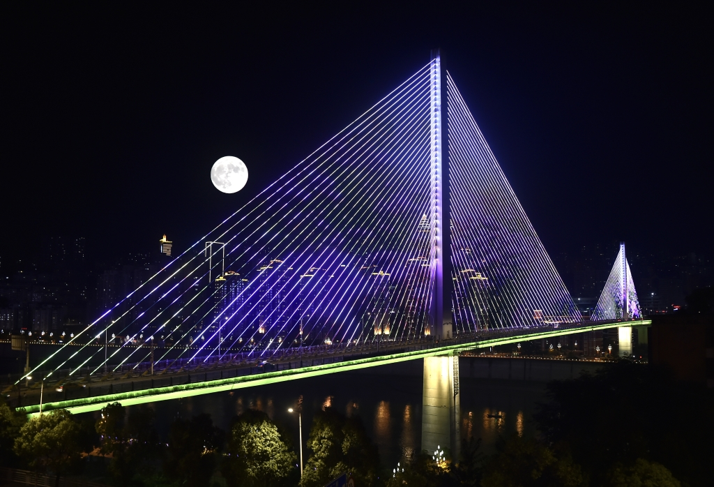 On the second bridge of Wujiang River in Fuling, the bright moonlight of Super Moon and the neon lights in the city complement each other. (Photographed by Huang He)
