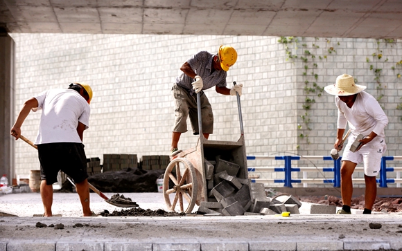 在快速路一纵线北碚段项目施工现场，工人正在铺设人行道地砖。通讯员 霍吕 摄